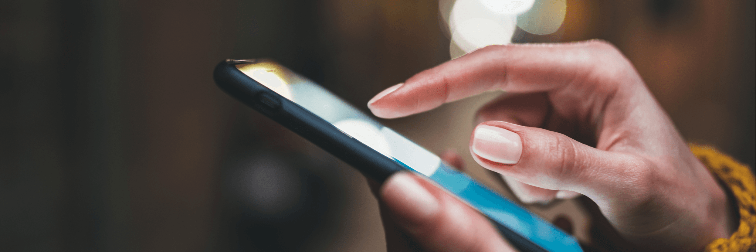 Ręka zbliżająca się do ekranu telefonu